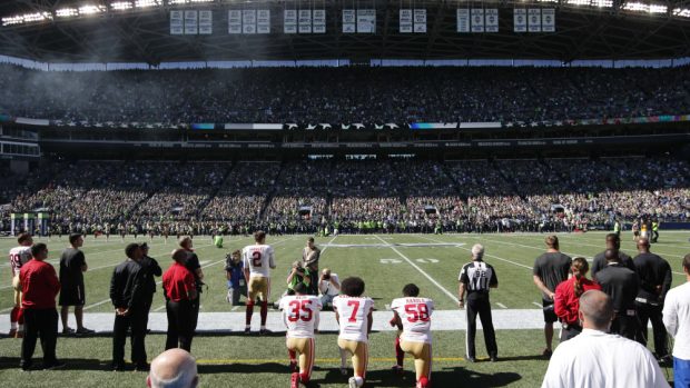 Hráč amerického fotbalu Colin Kaepernick (7) má zastání u spoluhráčů