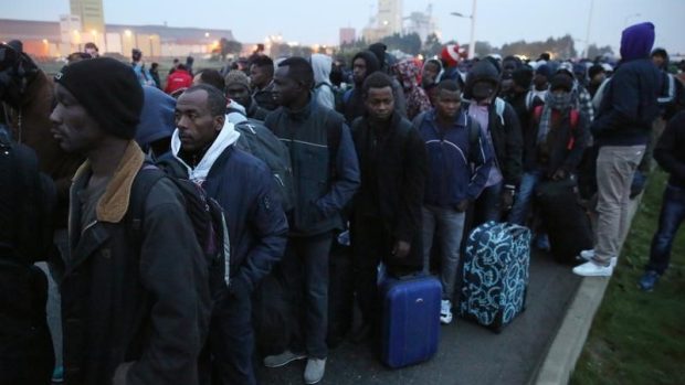 Migranti se zavazadly čekají na odvoz z uprchlického tábora u Calais, takzvané Džungle