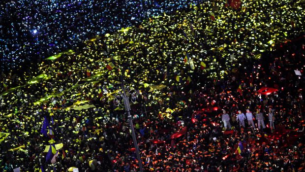 Protivládní demonstranti na náměstí Vítězství v Bukurešti vytvořili rumunskou vlajku