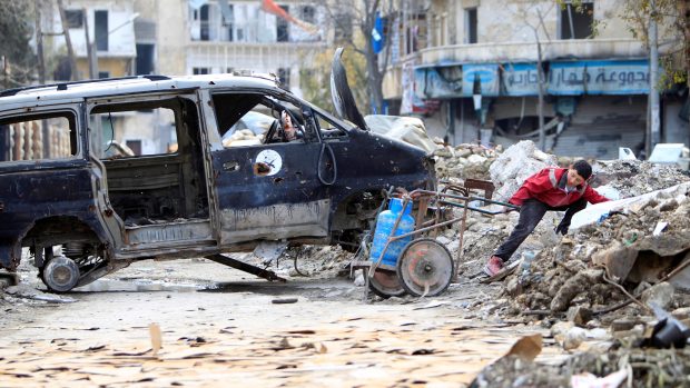Chlapec plynovou lahev ve zdevastovaném Aleppu táhne (fotografie z ledna)