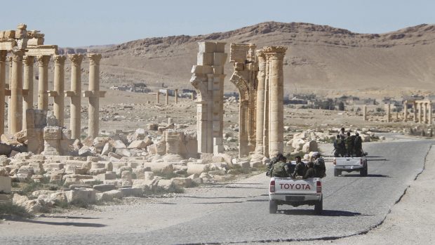 Vojáci syrské armády míjí Vítězný oblouk v historické Palmýře