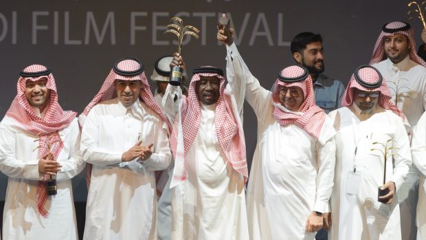Cenou Saúdského filmového festivalu je Zlatá palma. Z čestného ocenění se na snímku z letošního zahajovacího ceremoniálu raduje režisér a herec Saed Chádir (uprostřed).
