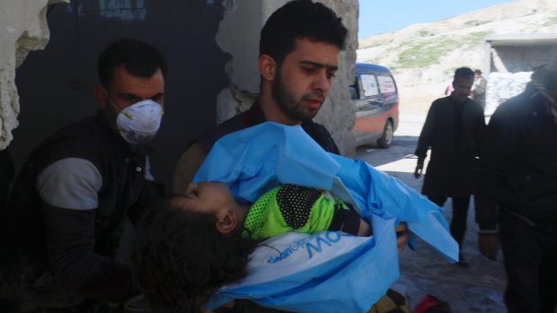 Muž nese tělo mrtvého dítěte po chemickém útoku v Idlibu