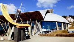 Olympijské muzeum v norském Lillehammeru zvenku, vzadu skokanské můstky