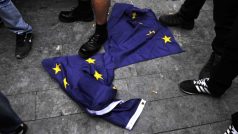 Účastníci protestu šlapou po roztrhané vlajce Evropské unie