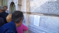 Řečtí důchodci čtou vládní vyhlášku na zdi banky
