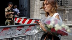 Žena nese květiny k francouzské ambasádě v Římě