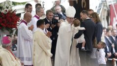 Papež František žená dítěti během mše připomínající 1050. výročí křtu prvního polského panovníka