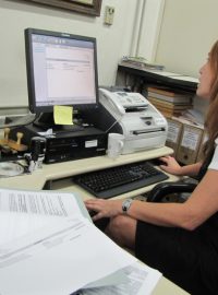 Zaměstnankyně volebního střediska ukazuje počítač, kam se údaje z disket nahrávají