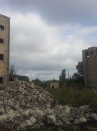 Suť zdemolovaných budov a budovy, které zůstanou stát