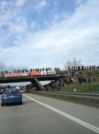 Konvoj na D1 nedaleko Brna. Vojákům na mostě mávají desítky lidí