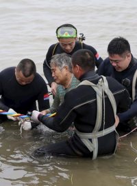 Záchranáři vytahují z vody přeživší pasažéry