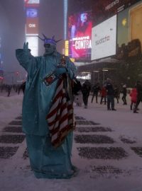 Muž v kostýmu sochy svobody na zasněžené newyorské ulici