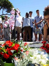 Žena pokládá kytici poblíž místa útoku v Nice