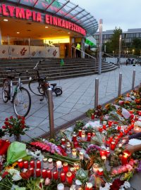 Lidé přinášejí svíčky a květiny k obchodnímu centru Olympia v Mnichově