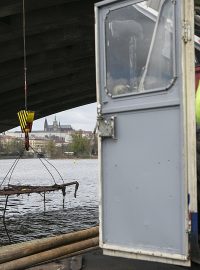 Jeřábník nastartoval techniku na remorkéru, který stojí pod Jiráskovým mostem na Rašínově nábřeží.