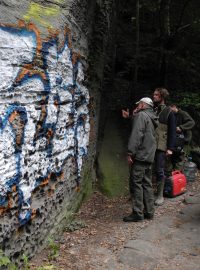 Neznámý vandal posprejoval pískovcovou skálu stříbrnou, modrou a červenou barvou
