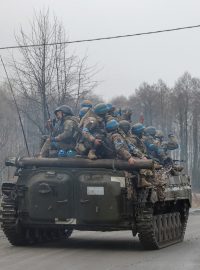 Žena salutuje bojovému vozidlu pěchoty vezoucímu ukrajinské vojáky u Černihivu