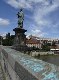 Modré nápisy v angličtině jsou na pravé straně zábradlí směrem k Pražskému hradu asi od poloviny mostu