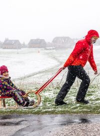 Muž v Krkonoších táhne dítě na saních (Horní Malá Úpa, Trutnovsko)