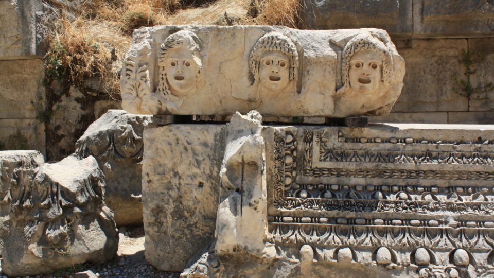Divadelní masky vytesané do kamene v Myre