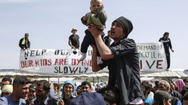 Lidé v ilegálním uprchlickém táboře v Idomeni u hranice s Makedonií protestují proti jeho vyklizení