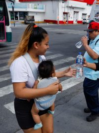 Mexická policistka rozdává lahve s vodou, 9. května 2024